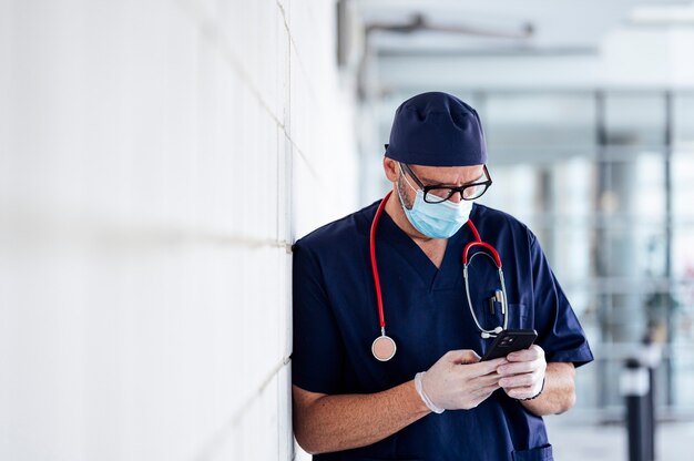 Doctor outside hospital using smart phone