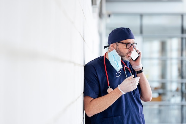 Doctor outside hospital using smart phone