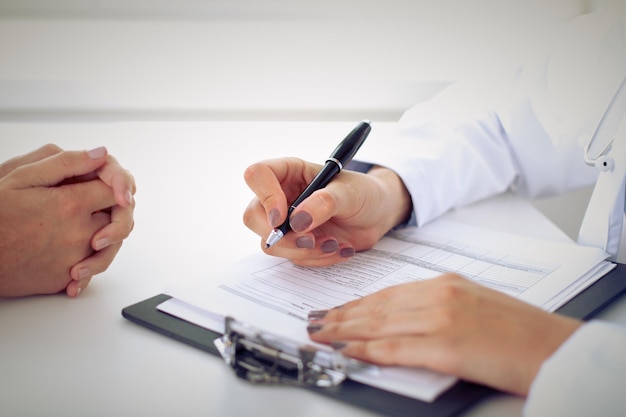 Doctor and patient are discussing something, just hands at the table.