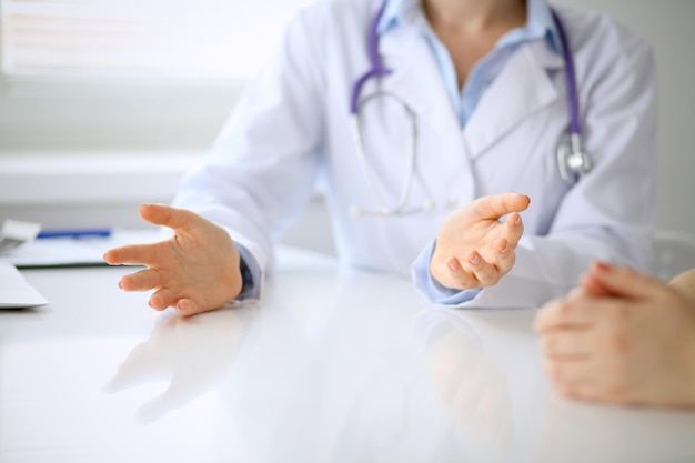 Doctor and patient are discussing something, just hands at the table.