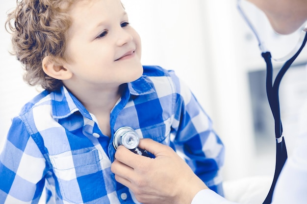 Doctor and patient child. Physician examining little boy. Regular medical visit in clinic. Medicine and health care concept.