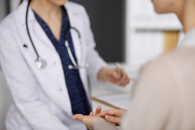 Doctor and patient discussing current health examination while sitting in clinic. Perfect medical service in hospital. Medicine concept.