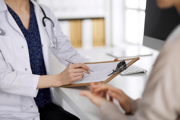 Doctor and patient discussing current health examination while sitting in clinic. Perfect medical service in hospital. Medicine concept.