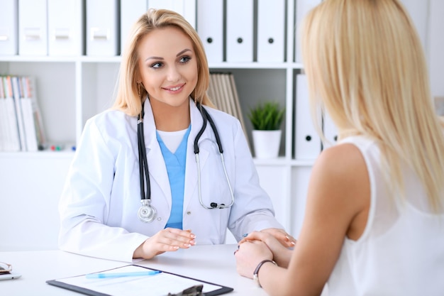 Doctor and patient discussing something while sitting at the table Medicine and health care concept