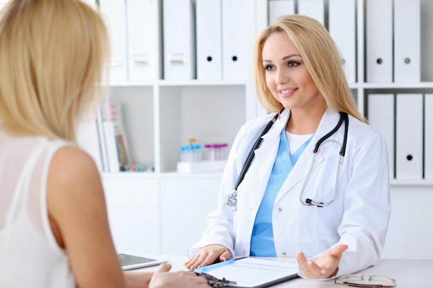 Doctor and  patient  discussing something while sitting at the table . Medicine and health care concept