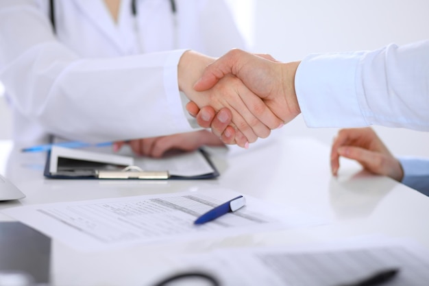 Doctor and patient handshaking Hands closeup