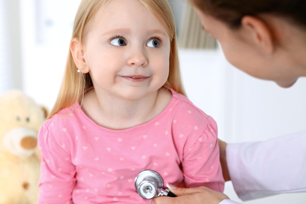 Doctor and patient in hospital Child being examined by physician with stethoscope