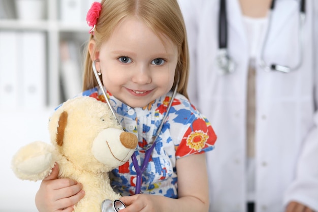 Doctor and patient in hospital Child being examined by physician with stethoscope