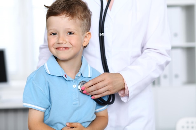 Doctor and patient in hospital Happy little boy having fun while being examined with stethoscope Healthcare and insurance concept