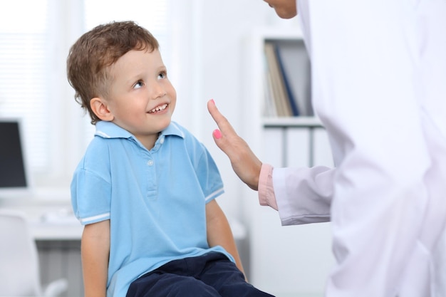 Doctor and patient in hospital Happy little boy having fun while being examined with stethoscope Healthcare and insurance concept