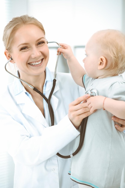 Doctor and patient in hospital. Little girl is being examined by doctor with stethoscope. Medicine concept.