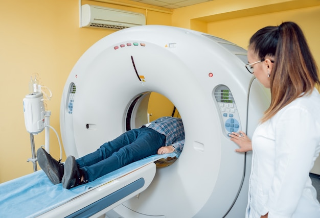 Doctor and patient in the room of computed tomography at hospital.