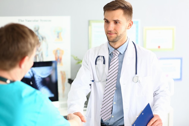 Doctor and patient shaking hands in clinic