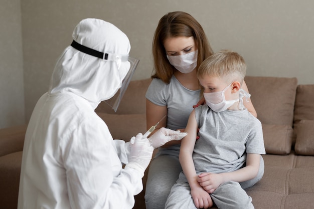 Doctor in personal protective suit or PPE inject vaccine shot