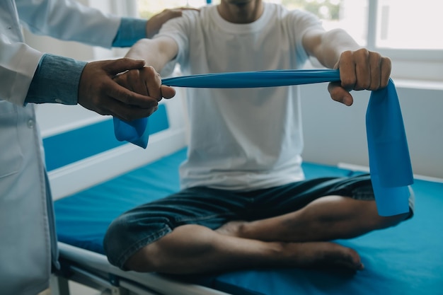 Photo doctor or physical therapist examines back pain and spinal area to give advice within the rehabilitation center