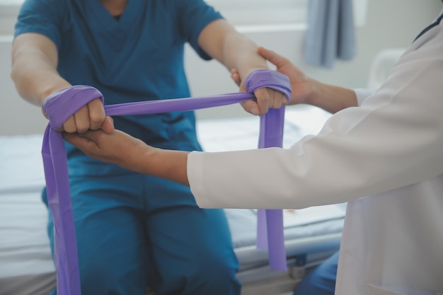 Photo doctor or physiotherapist working examining treating injured arm of athlete male patient stretching and exercise doing the rehabilitation therapy pain in clinic