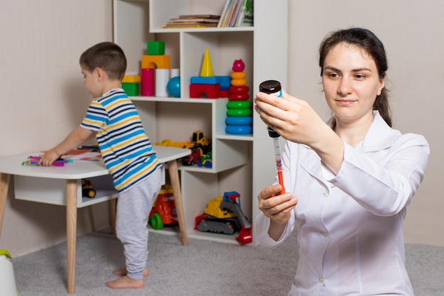 The doctor picks up from the bottle a sprinkle of cough