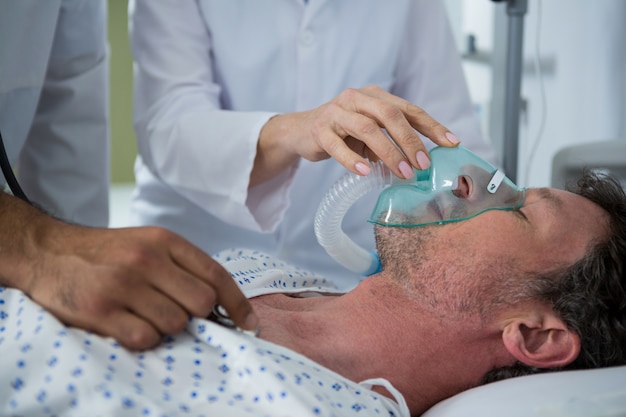 Doctor placing an oxygen mask on the face of a patient