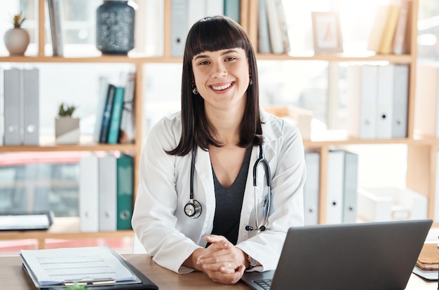 Doctor portrait and smile of woman in hospital office ready for healthcare and wellness Medical professional health and happy female physician from Canada with laptop for research and telehealth