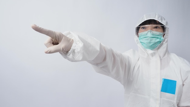 Doctor in PPE suit wearing white medical rubber gloves and clear goggles and green N95 face mask to protect pandemic Coronavirus gesture make hand sign Represent victory win over virus Isolated