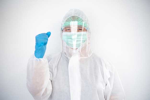 Doctor in a PPE uniform that prevents the COVID-19 situation and raises his fist.