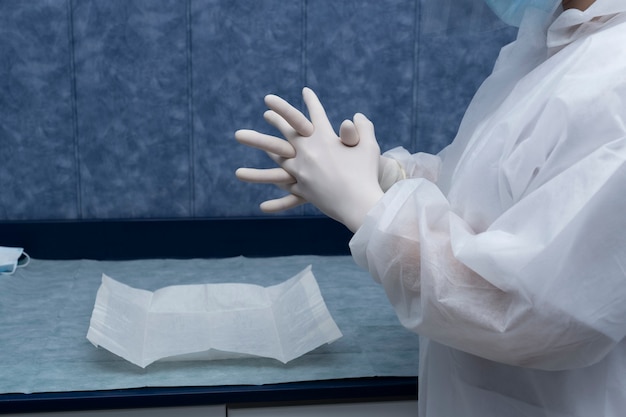 A doctor prepares to attend to a patient.
The woman prepares (protective suits,googles,gloves and masks) all the necessary protections to protect itself from covid-19