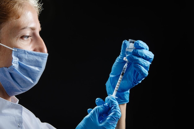 The doctor prepares to give the injection a female nurse fills the syringe with medicine