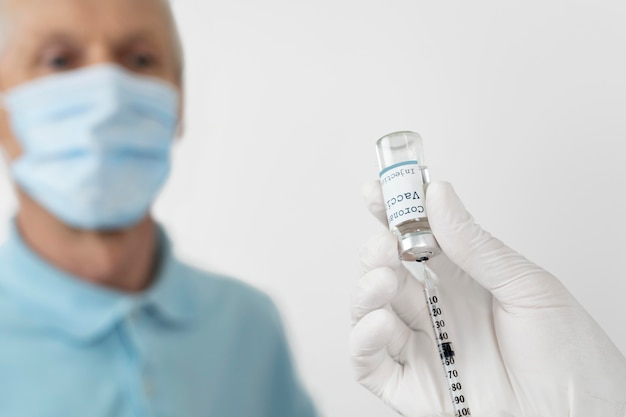 Doctor preparing to administer vaccine shot to male patient