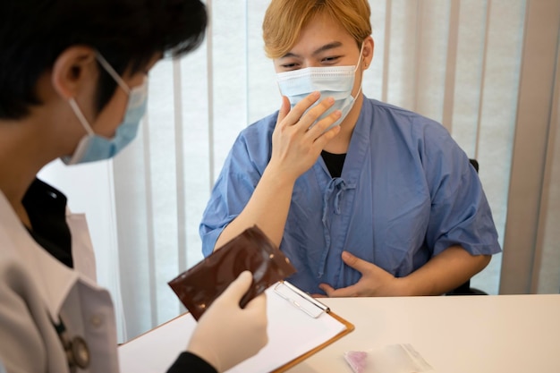 Doctor in protective mask explaining treatment plan to his patient