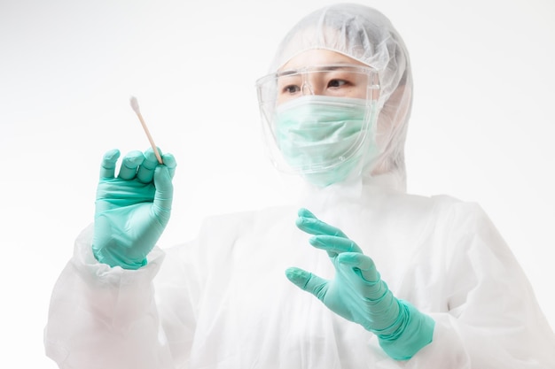 Doctor in protective suit PPE holding COVID-19 Nasal swab laboratory test. Medical worker performing Covid-19 test, taking nasal swab sample patient, PCR diagnostic, Rapid antigen test kit (ATK)