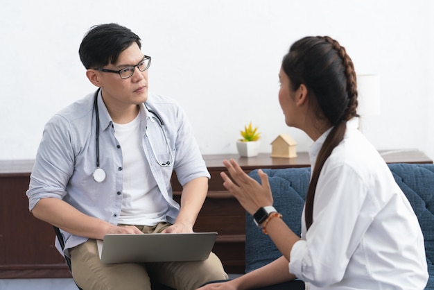 Doctor or Psychiatrist talking with Asian young woman patient about her illness at healthcare center