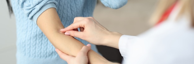 Doctor putting patch on patients forearm in clinic closeup rules for taking blood from vein