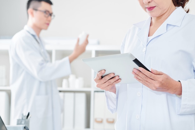 Doctor reading data on tablet screen