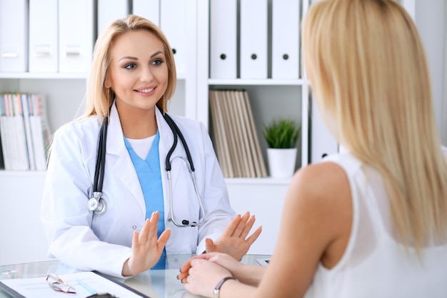 Doctor reassuring her female patient. Medicine, help and health care concept.