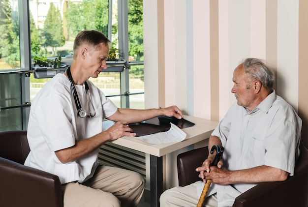 Doctor reviewing x-ray photo of the old man