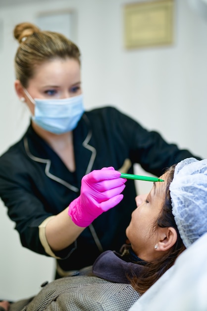 Doctor's hand in glove making marks on patient's face