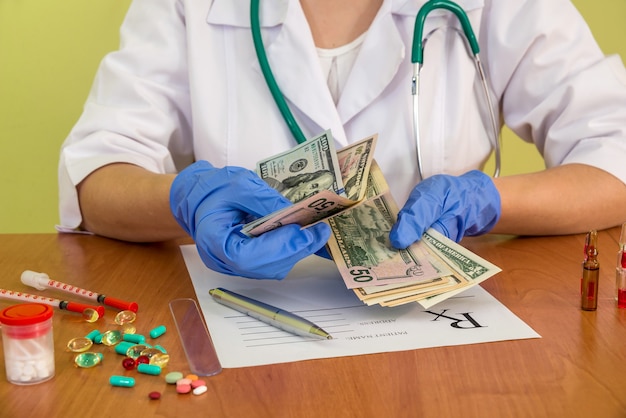 Doctor's hands counting dollar banknotes, close up