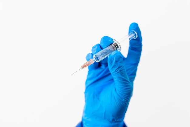 Doctor or scientist in PPE suite uniform holding medicine liquid vaccine