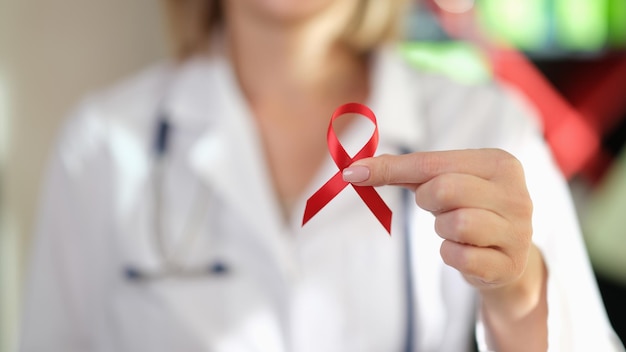 Doctor show red ribbon as symbol of world aids day international world aids day awareness