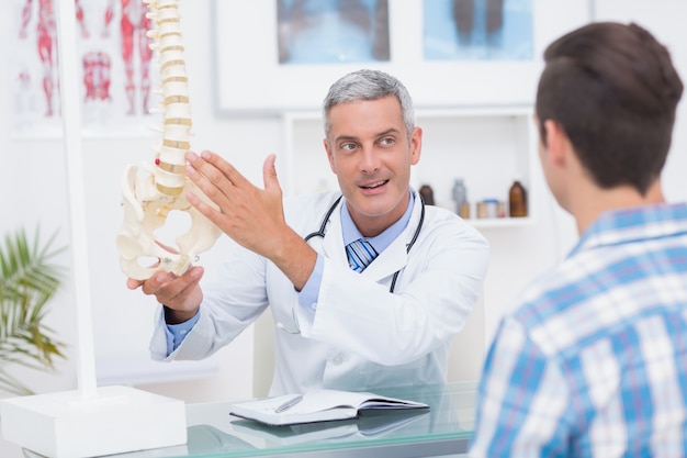  Doctor showing his patient a spine model