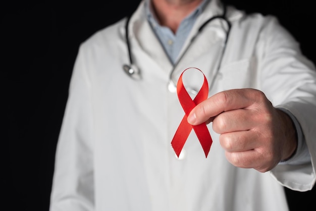 Doctor showing a red ribbon World AIDS Day Support from health personnel to people with hiv