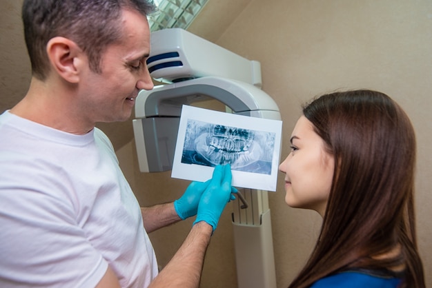 The doctor shows the patient an x-ray image. Computer diagnostics. dental tomography