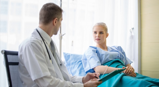 Doctor sitting by women patient and checking her situation