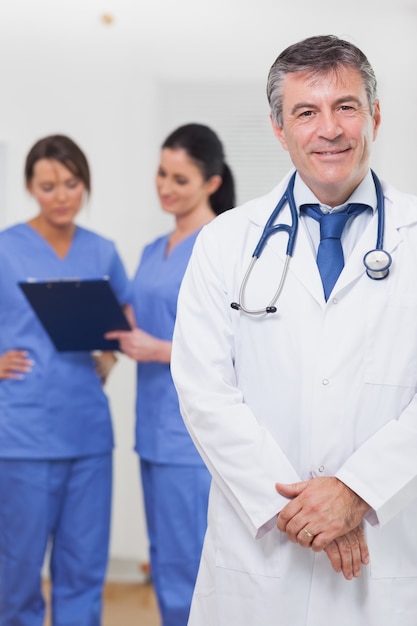 Doctor smiling with nurses behind him