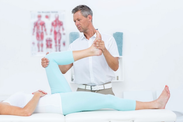 Doctor stretching his patients leg