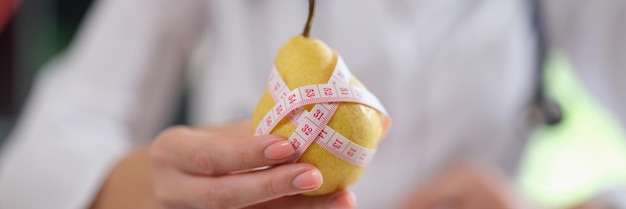 Doctor suggest eating fruits and food with vitamins nutritionist showing ripe yellow pear with