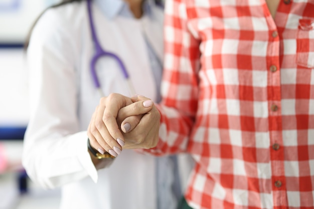 Doctor supporting patient by hand and helping to go to clinic rehabilitation after cerebral