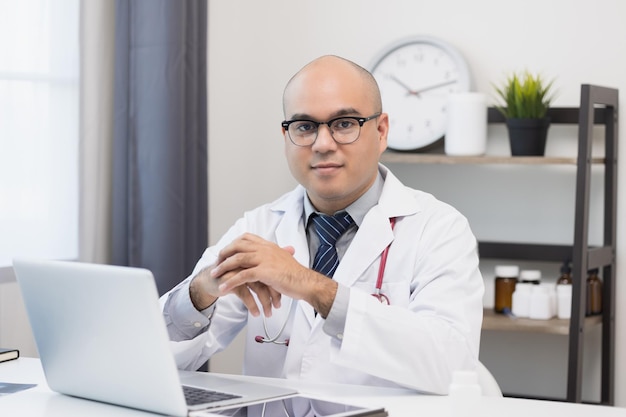 Doctor talks to patient via online video conferencing with computer laptop wearing headset Explain about taking medications to treat illnesses