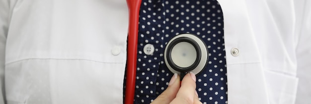 Doctor therapist holding stethoscope near his chest closeup