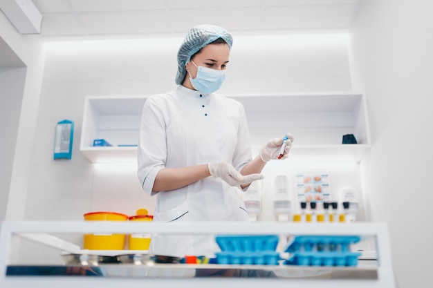 The doctor took a blood sample from the patient Test tubes with blood in hands